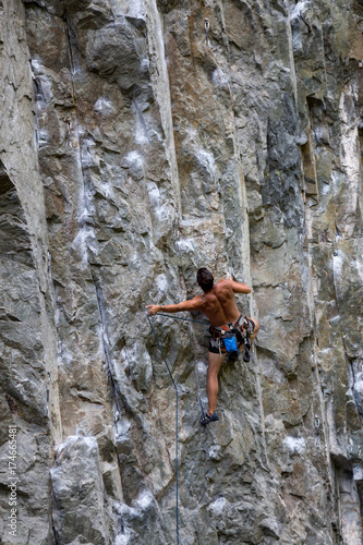 Rock climber clipping rope on a sport route in Squamish, British Columbia, Canada.