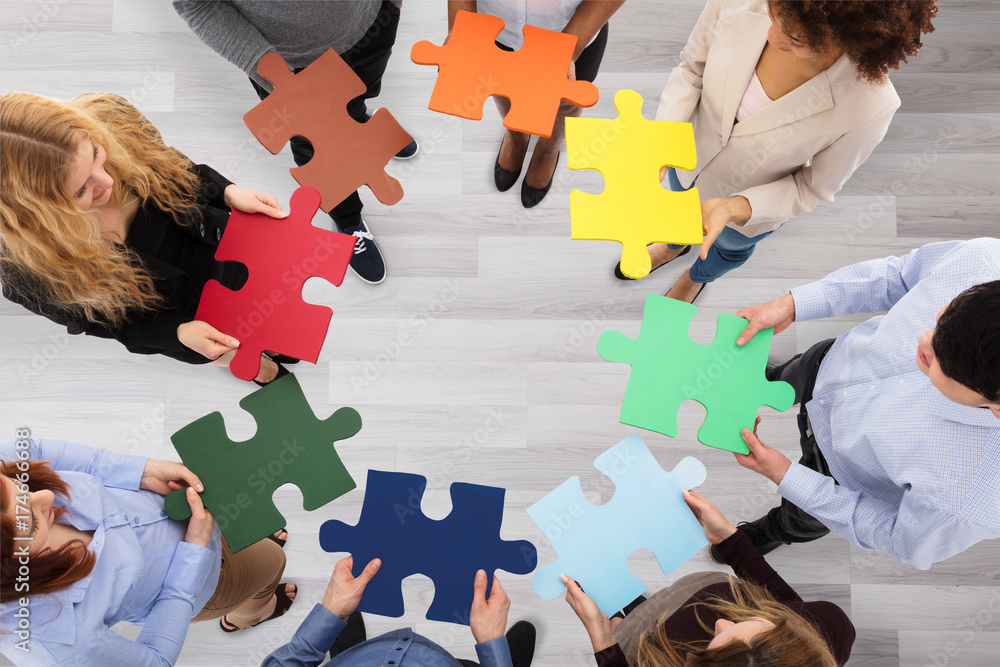 Group Of Business People Holding Colorful Jigsaw Puzzles - obrazy, fototapety, plakaty 