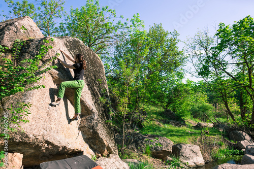 Climber is bouldering outdoors.