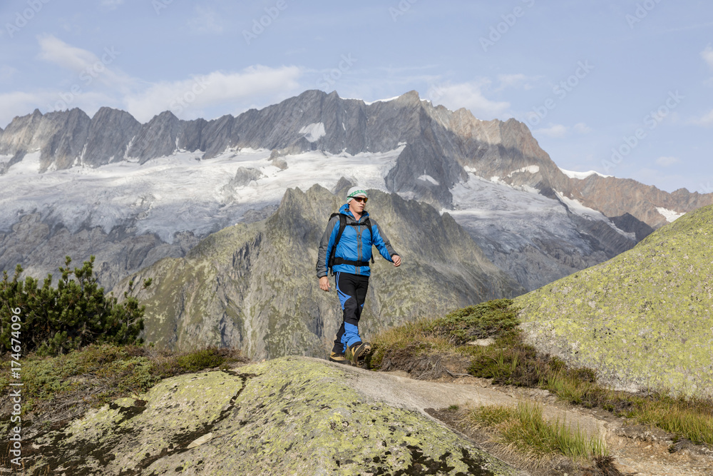 Hiker hikes through a breathtaking alpine landscape in the mountains of Central Switzerland