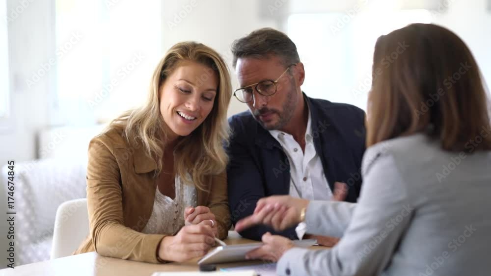 Mature couple meeting real-estate agent in office Mature couple meeting real-estate agent in office