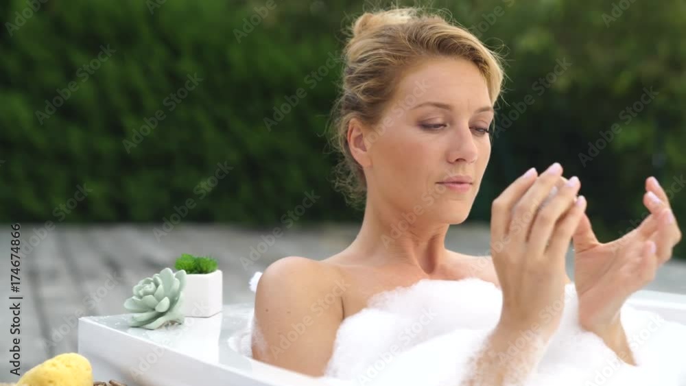 Beautiful woman in bath and using nailbrush