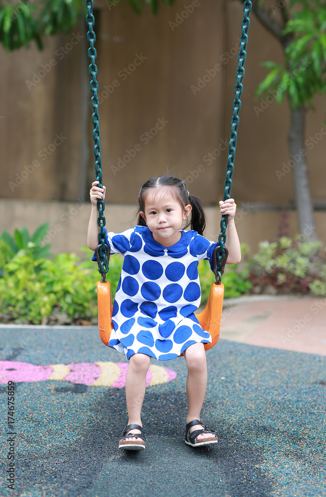 Asian little enjoy playing swing in the playground. Asian little enjoy playing swing in the playground.