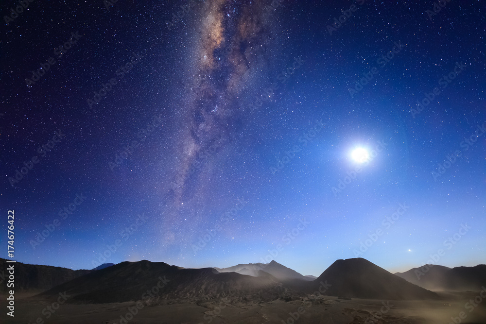 Bromo volcano with milky way, the moon and sand strom Tengger Semeru national park, East Java, Indonesia