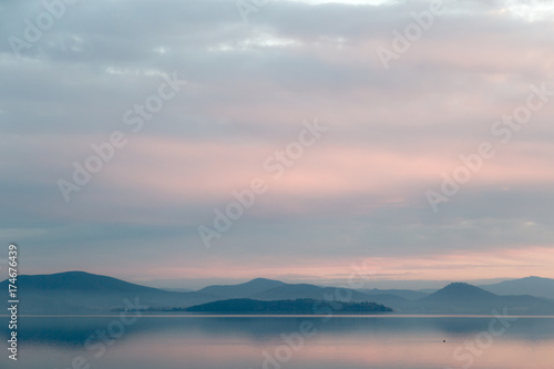 A lake at dusk  with beautiful  warm tones in the sky and water