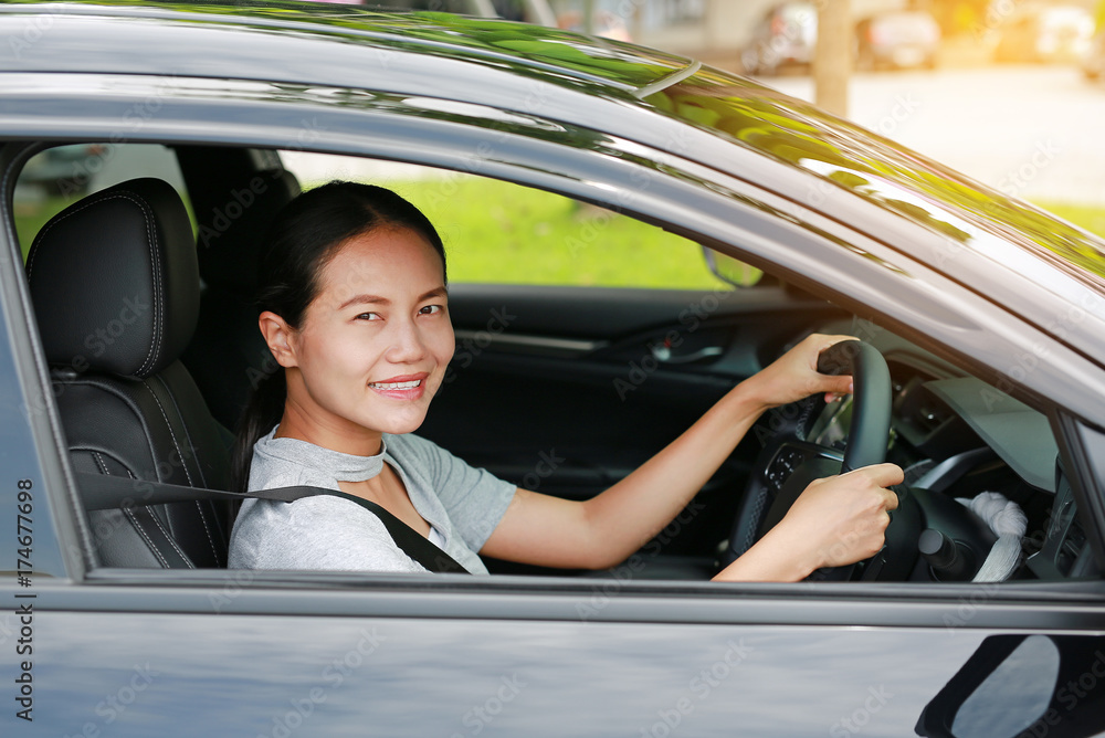 Beautiful asian woman driving a car with looking camera and smiling. Beautiful asian woman driving a car with looking camera and smiling.