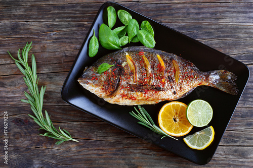 Schilderij op canvas grilled whole fish on black plate