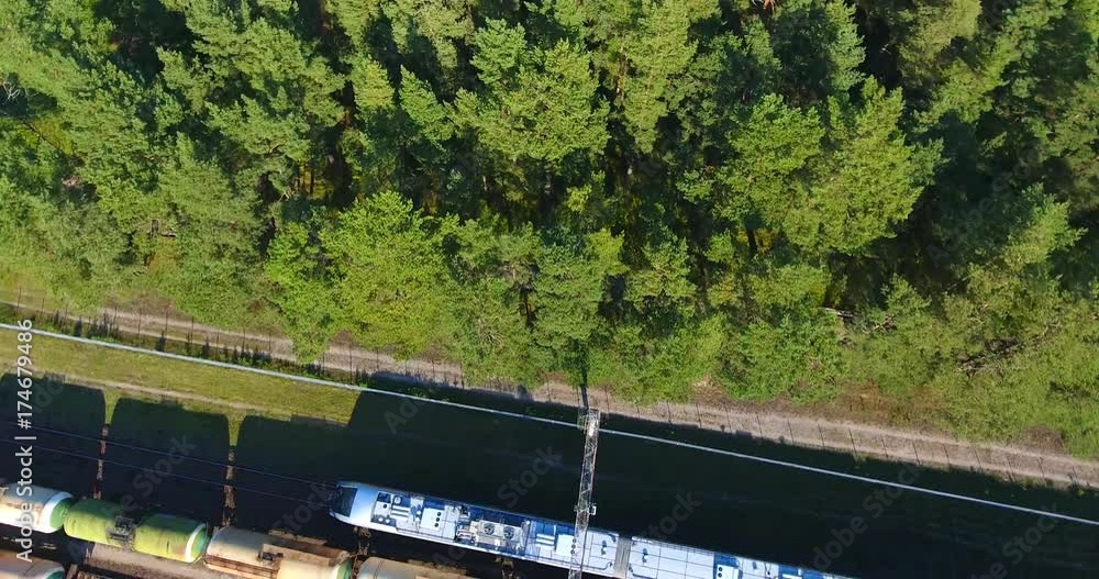 AERIAL railway: passenger train moving across the wagon station and autumn forest AERIAL railway: passenger train moving across the wagon station and autumn forest