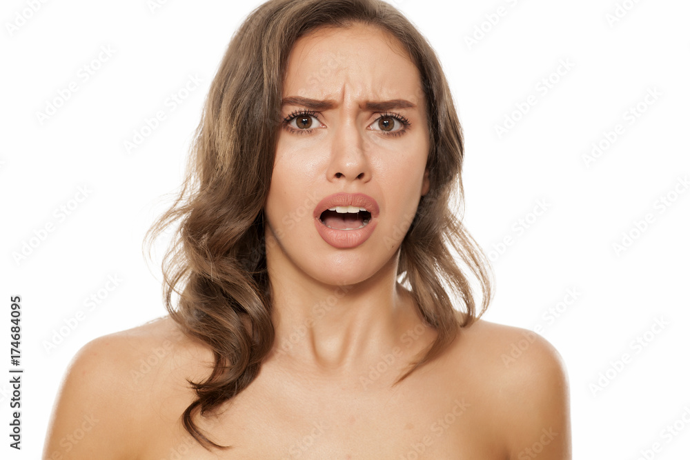 Portrait of beautiful young negatively surprised woman on white background Portrait of beautiful young negatively surprised woman on white background