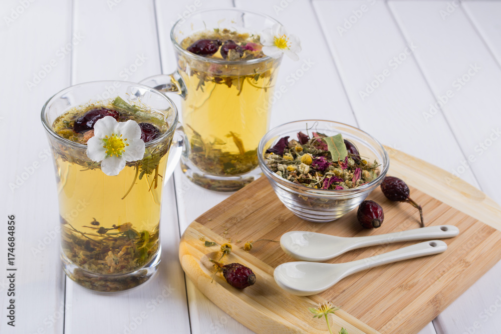 Tea of useful herbs and flowers. Two glass cups. Tea ingredients