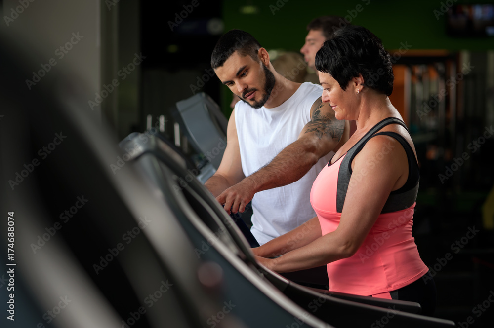 Personal coach talking with female client in gym Personal coach talking with female client in gym