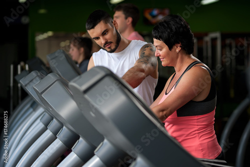 Fitness coach assisting his client on treadmill © pavel_shishkin