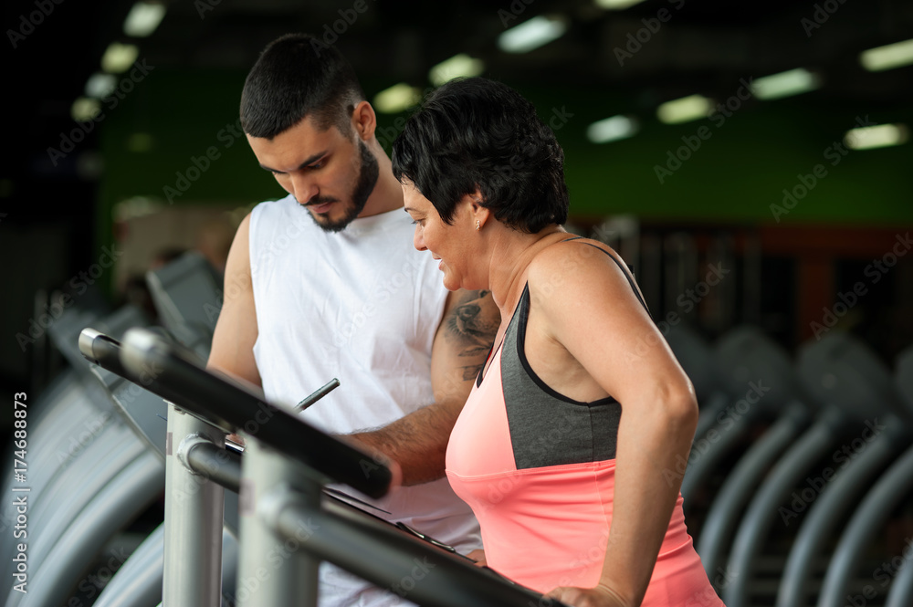Middle aged woman working out with personal coach Middle aged woman working out with personal coach