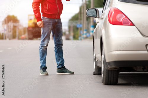 Man standing near broken car after breakdown