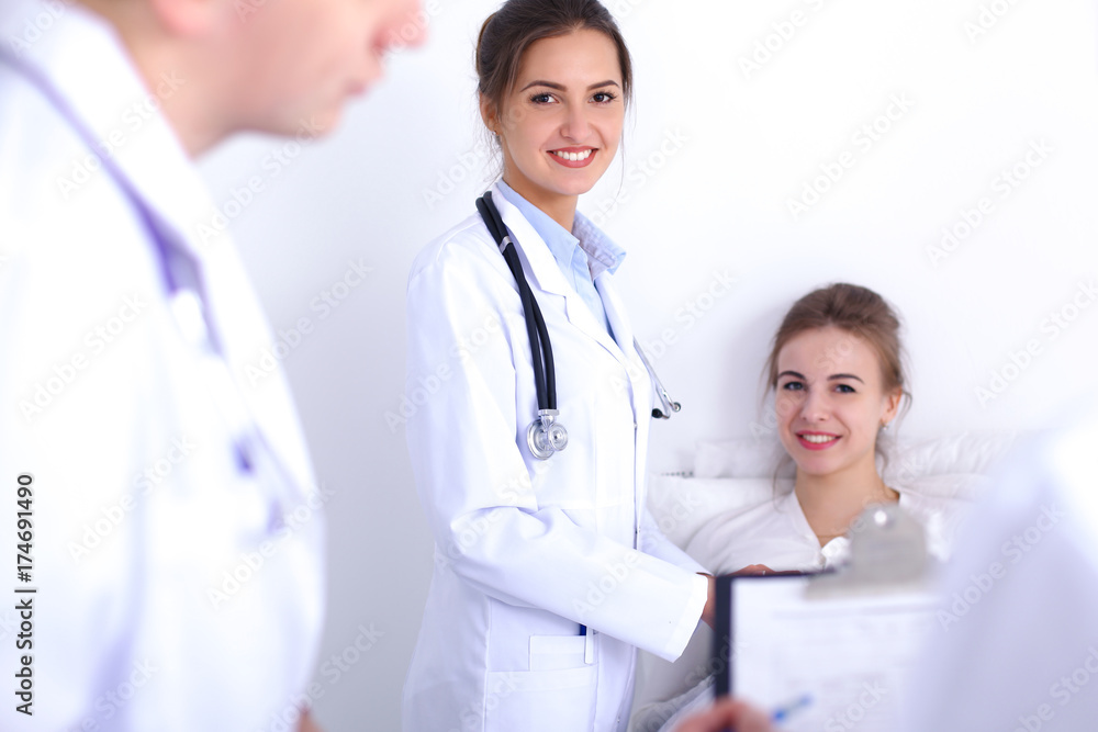 Female doctor smiling on the background with patient in the bed Female doctor smiling on the background with patient in the bed