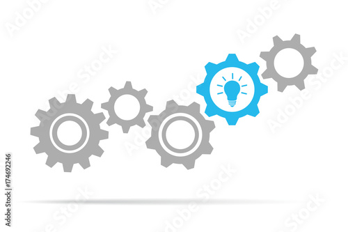 graue zahnräder mit blauer glühbirne