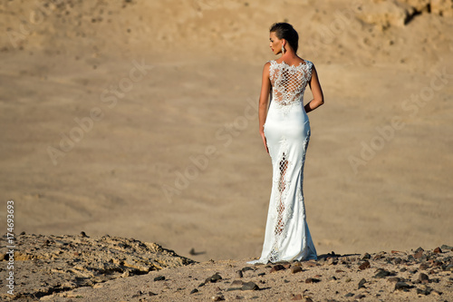 Woman or girl in white sexy dress standing in dunes