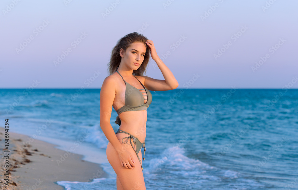Happy carefree woman on the beach enjoying summer
