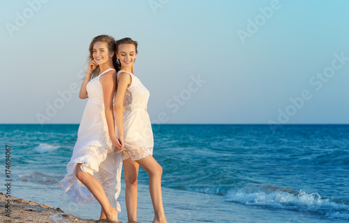 Two women in a white dress on beach © fotofabrika