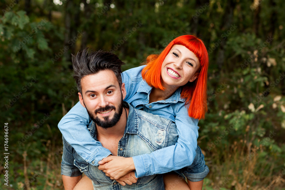 Handsome guy giving piggyback ride to girlfriend