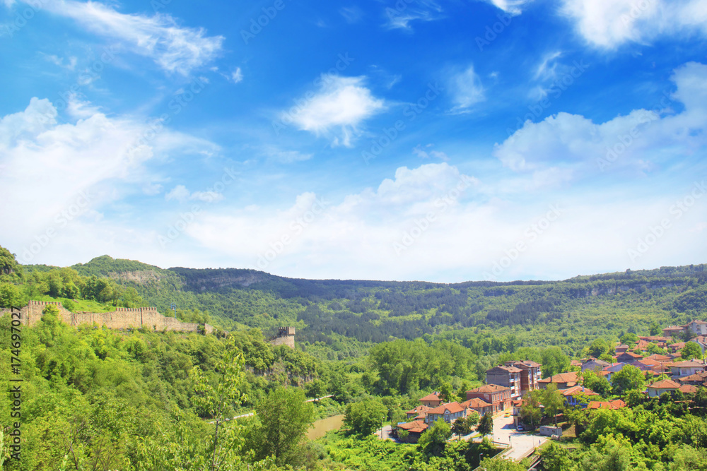 A beautiful view of the Tsarevets fortress among the green hills in Veliko Tarnovo, Bulgaria