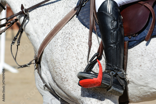 Gray sport horse and rider on gallop. Horse show jumping in details.