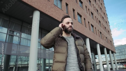 Wallpaper Mural Man talking on cell phone outdoors. The bearded man.Man looks happy Torontodigital.ca