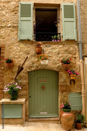 Picturesque stone facade with flowering plants medieval village of Valbonne, Provence, France
