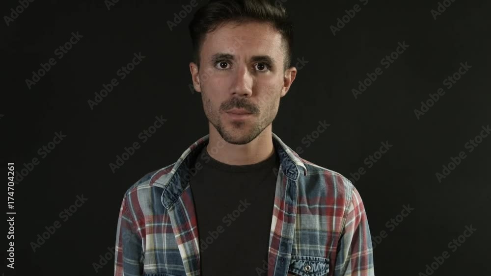 Portrait of young man sending a kiss, looking at camera on neutral black background Portrait of young man sending a kiss, looking at camera on neutral black background