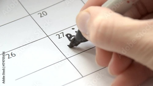 Writing BIG DAY on calendar with a black marker photo