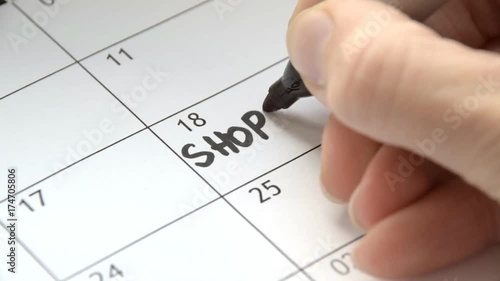 Writing SHOPPING on calendar with a black marker