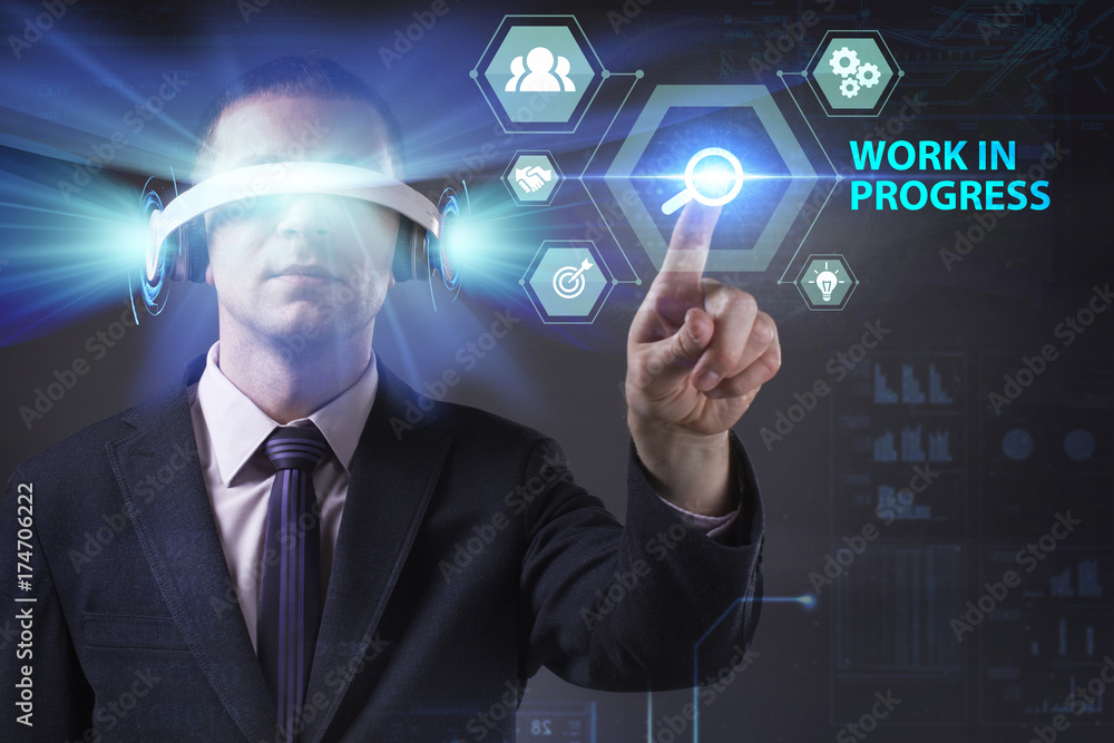 Business, Technology, Internet and network concept. Young businessman working in virtual reality glasses sees the inscription: Work in progress Business, Technology, Internet and network concept. Young businessman working in virtual reality glasses sees the inscription: Work in progress