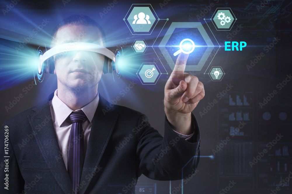 Business, Technology, Internet and network concept. Young businessman working in virtual reality glasses sees the inscription: ERP Business, Technology, Internet and network concept. Young businessman working in virtual reality glasses sees the inscription: ERP