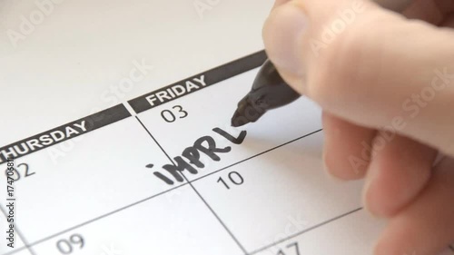 Writing IMPREGNATION on calendar with a black marker