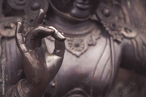 Detail of Buddha statue with Karana mudra hand position photo