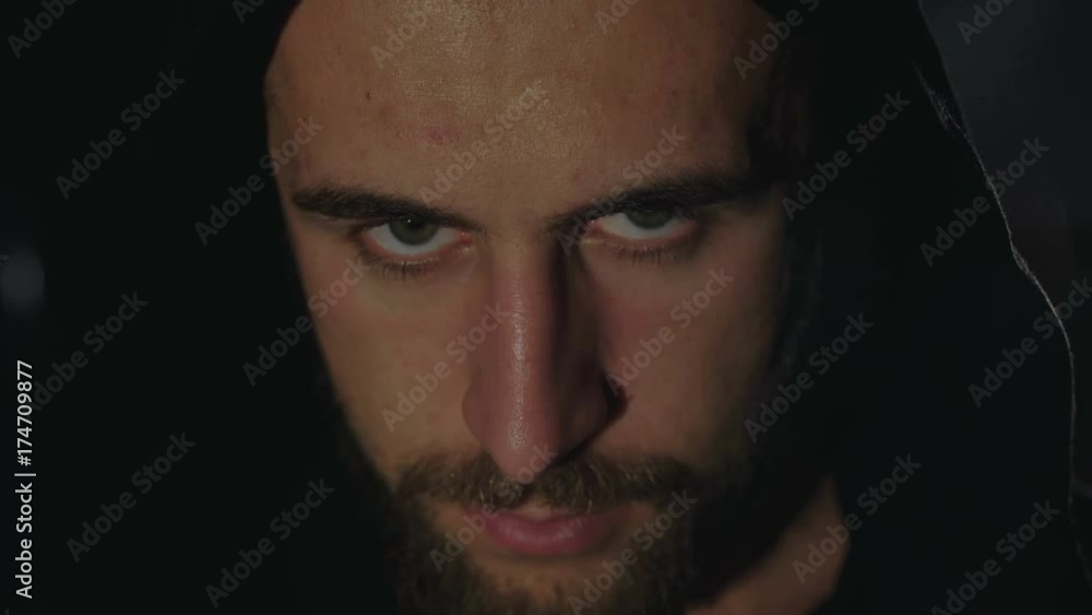 Strong look at camera of a sweaty man in black cloak in darkness. 4K Strong look at camera of a sweaty man in black cloak in darkness. 4K