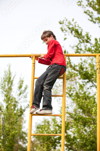 Happy kid boy on top of gymnastics ladder