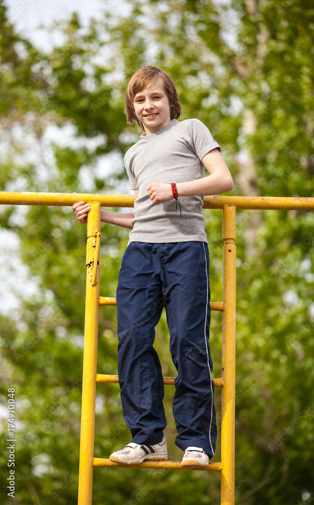 Happy kid boy on top of gymnastics ladder Happy kid boy on top of gymnastics ladder