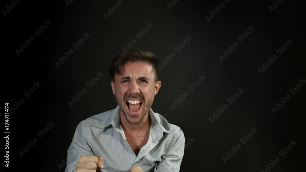 Winning man exulting looking at camera on neutral background Winning man exulting looking at camera on neutral background