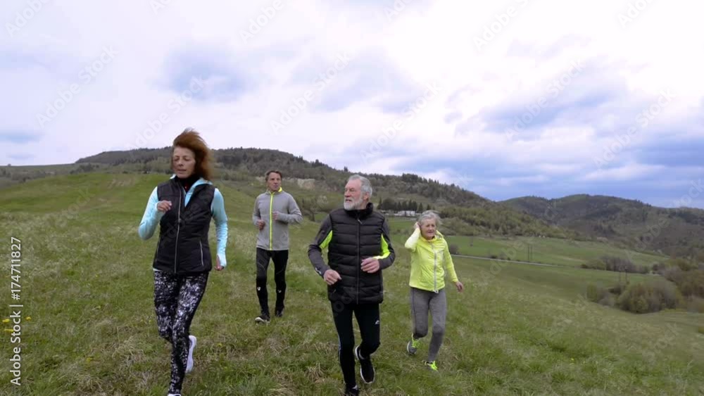 Group of seniors running outside on the green hills. Group of seniors running outside on the green hills.