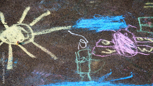 Children's drawings on sidewalk in park.