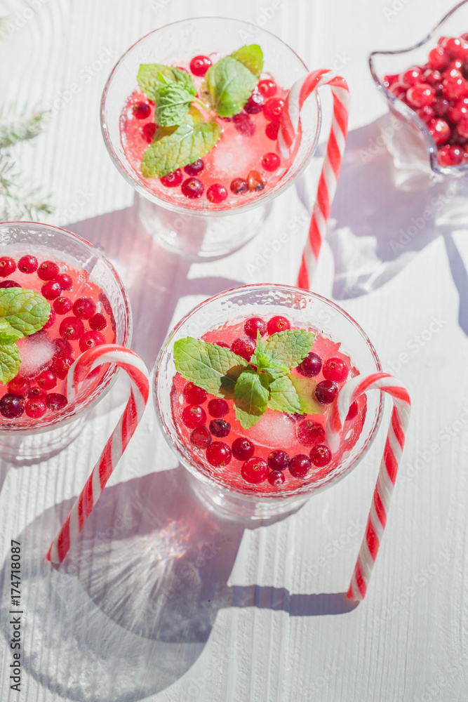 Cranberry drinks with lollipop candy cane on white rustic wooden table, Christmas background Cranberry drinks with lollipop candy cane on white rustic wooden table, Christmas background