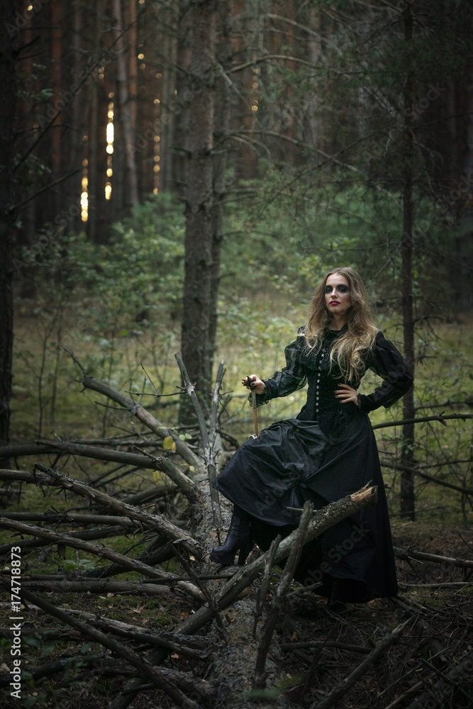 Halloween. beautiful girl in a black dress in the forest. Halloween. beautiful girl in a black dress in the forest.