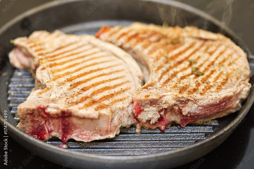 Roasted fresh pork meat steak in a frying grill pan Roasted fresh pork meat steak in a frying grill pan