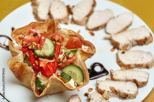 Food tray with delicious greek salad with pine nuts and meat