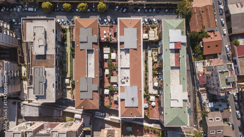 Vista aerea perpendicolare dei tetti di alti palazzi adibiti ad uso residenziale in una grande città italiana. Le automobili e le persone dall'alto sembrano molto piccoli. photo