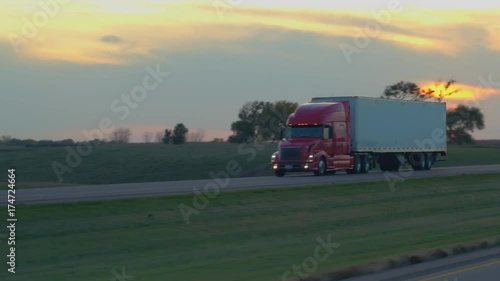 FPV: Driving along the busy heavy traffic highway running through scenic countryside at gorgeous morning in United States. People on road trip traveling, freight container semi trucks freighting goods photo