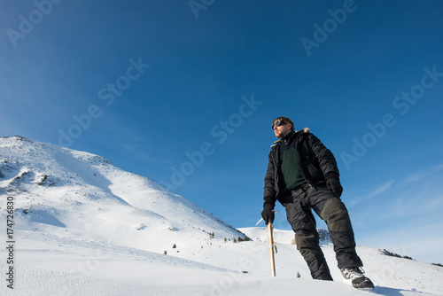 climber with an ice ax in the snowy mountains