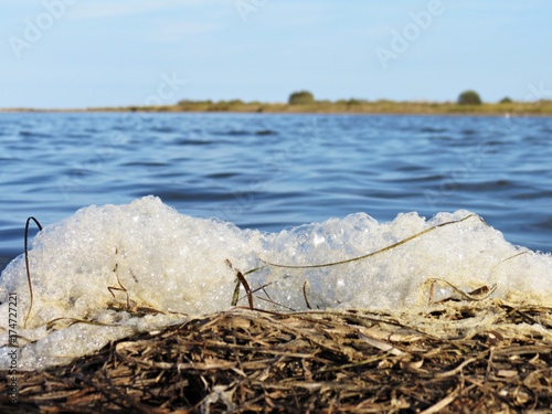 Espuma contaminante en la orilla de un río photo