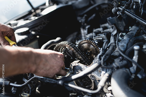 Car service worker working on automobile engine repair